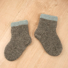 Handgestrickte Babysocken mit hellblauem Rand