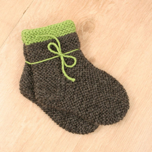 Handgestrickte Babysocken mit grünem Rand