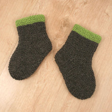 Handgestrickte Babysocken mit grünem Rand