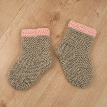 Handgestrickte Babysocken mit rosa Rand