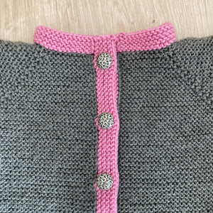 Handgestrickter Babyjanker mit pinkem Rand